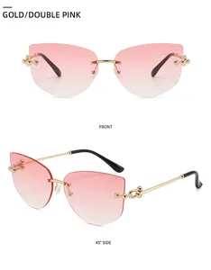 Detail of rimless cat-eye sunglasses with gold metal chain arms and pink gradient lenses