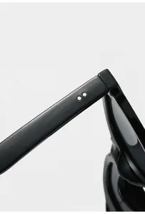 Detail shot of glossy black eyeglass temples with silver rivet decor and flexible hinges