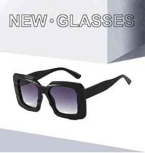 Detail of square oversized sunglasses with irregular black frames and purple gradient lenses
