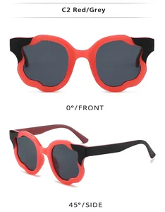 Detail view of wavy irregular red and black sunglasses frames with dark grey lenses