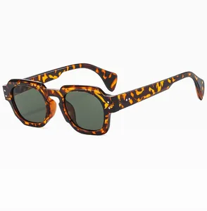 Detail view of tortoiseshell polygonal sunglasses featuring silver triple-dot rivet accents