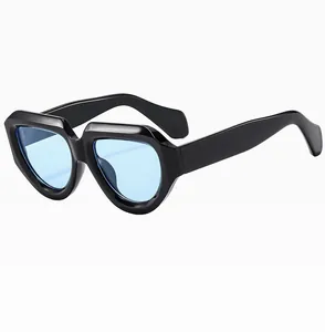 Detail view of bold square frame sunglasses with blue lenses and curved black temples