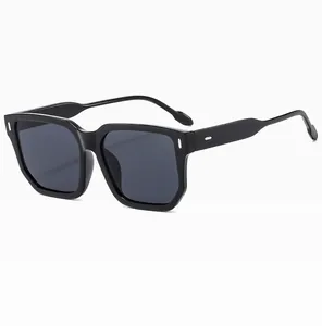 Détail de lunettes de soleil carrées noires avec décorations métalliques blanches sur les branches