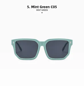 Détail de lunettes de soleil carrées vert menthe avec rivets en métal et verres gris
