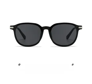 Detail of black oval sunglasses with silver horizontal accents and dark lenses