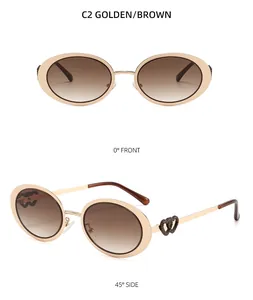 Detail view of oval gold metal sunglasses with brown gradient lenses and heart-shaped temples