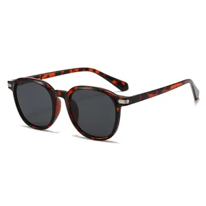 Oval tortoiseshell sunglasses with dark lenses and silver metal detail on frame