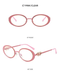 Detail view of pink oval frames featuring decorative double heart metal accents on temples