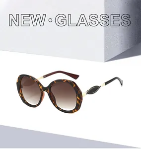 Nahaufnahme einer Schildpatt-Sonnenbrille mit goldfarbenen Metallscharnieren und braunem Verlauf