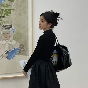 Retro black high-gloss shoulder bag with cartoon print styled in an art gallery setting