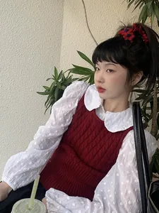Detailed view of a vintage knitted wine red floral hair claw clip on model's hairstyle