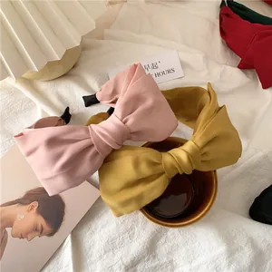 Close-up of elegant satin bow headbands in pink and black with anti-slip ends