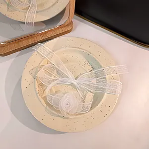 Detailed close-up of a white lace camellia choker necklace on a vintage ceramic plate