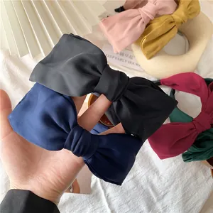 Macro shot of satin bow headbands in various colors on a soft decorative background