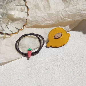 Cute cartoon hair elastic set featuring yellow duck and pink carrot charms on a soft base