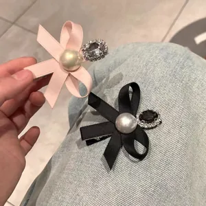 Elegant bow hair clips in pink and black colors with pearls and sparkling rhinestones