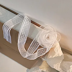 Close-up of elegant white lace choker with 3D mesh camellia flower and ribbon texture