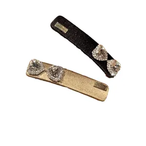 Sparkling rhinestone heart bow hair clips in black and gold for women and girls