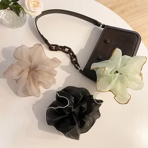 Vue détaillée de chouchous géants en organza en noir, vert et couleurs champagne
