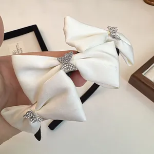 Gros plan détaillé du serre-tête noir avec nœuds en satin blanc et papillons en strass