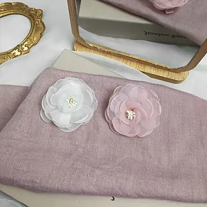 Detailed close-up of pink and white mesh camellia hair clips with elegant pearl centers