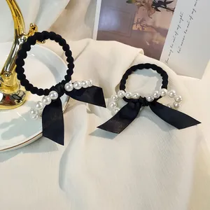 Élastiques à cheveux noirs élégants avec perles et nœuds en satin sur un support