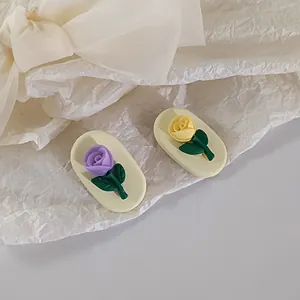 Detail of cream base hair clips featuring 3D lavender and yellow rose flower designs