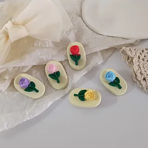 Detailed view of colorful cream-style rose flower hair clips set on lace decor