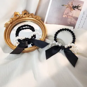 Élastique à cheveux chic avec nœud en soie noire et perles blanches sur mousseline blanche