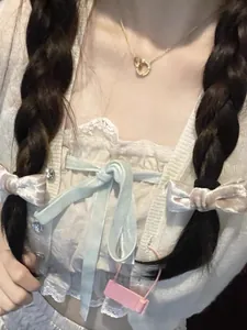 Close-up of a delicate gold double-ring necklace on a model wearing a sweet style outfit