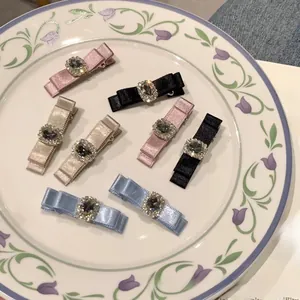 Detailed set of seven satin bow hair clips with crystal rhinestones in varied colors
