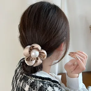 Élastique cheveux fleur en soie champagne avec perle centrale pour coiffure élégante