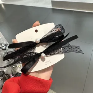 Elegante coppia di fermagli per capelli in pizzo e raso nero con perle su carta