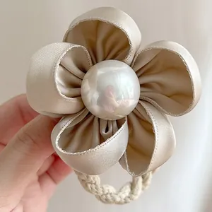 Chouchou fleur de camélia en satin champagne élégant avec centre en perle blanche