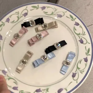 Close-up of seven bow hairpins with rhinestones on a decorative ceramic plate
