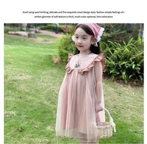 Detailed view of floral embroidery on pink tulle dress and matching checkered headscarf