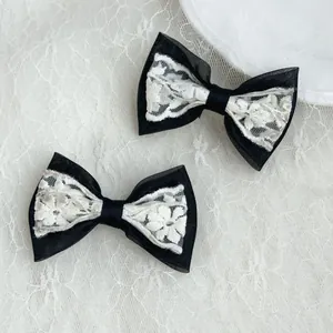 Detail of elegant black and white lace bow hair clips on a delicate lace background