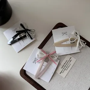 Three-piece retro velvet bow hair clips with pearls on a wooden display tray
