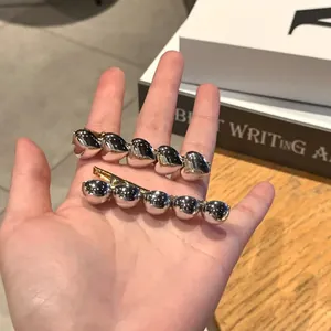 Silver heart and bead hair clips with gold metal base shown in a hand-held lifestyle shot