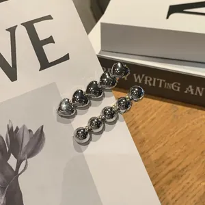 Detailed view of silver heart and bead metal hair clips set on artistic paper card