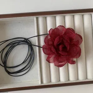 Dettaglio della collana girocollo bordeaux con petali di fiori in organza multistrato