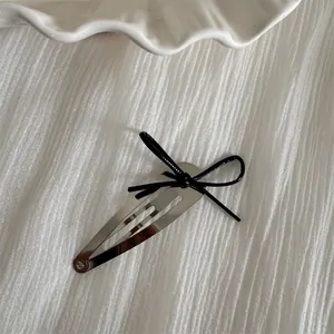 Elegant silver waterdrop hair clip featuring a delicate black ribbon bow ornament