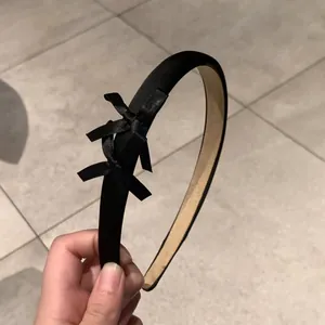 Détail d'un serre-tête noir en tissu avec trois nœuds en soie et doublure antiglisse