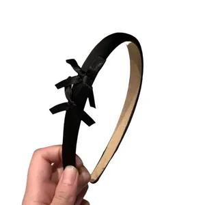 Elegant black velvet headband featuring triple silk bow accents and non-slip lining