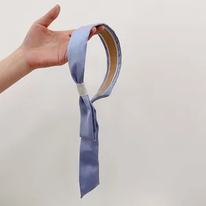 Detail of satin fabric headband with long streamers and brown non-slip inner lining