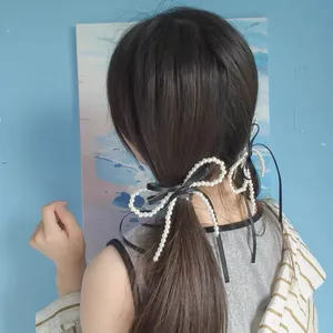 Elegant pearl bow hair clip with black ribbon tied on a ponytail for women's hairstyle