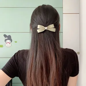 Elegant light green satin bow hair clip featuring a pink heart rhinestone on long hair