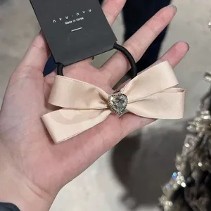 Elegante elastico per capelli con fiocco in raso champagne e cuore di cristallo nyunyu