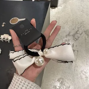 Elegant white satin bow hair tie with pearls and black stitched edges for women