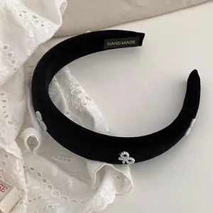 Close-up of black velvet headband with silver bow beads and Hand Made gold lettering